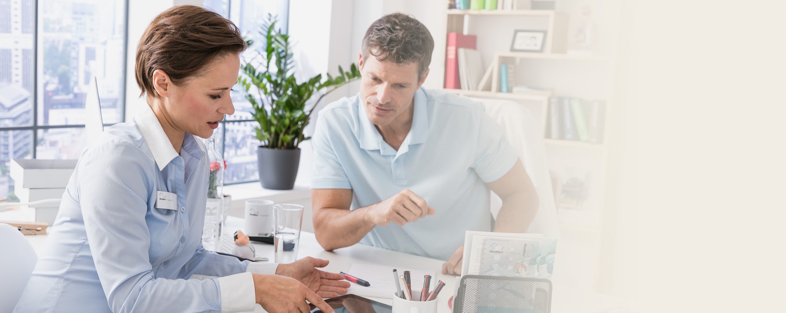 Ein Arzt bespricht mit einer Fachkraft in einem modernen Büro die Details einer Schlafapnoetherapie