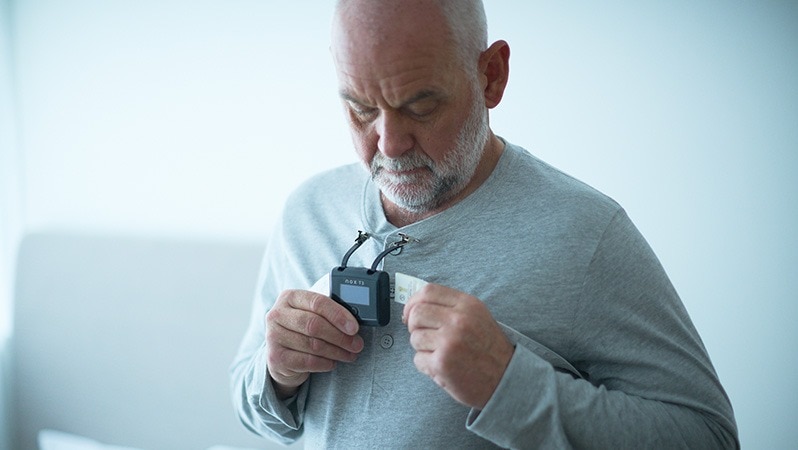 Mann verwendet Polygraphie-Gerät für Schlafdiagnostik.