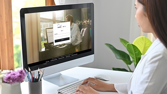 Frau sitzt vor einem Computer und nutzt das AirView™-Telemonitoring-Portal von ResMed.