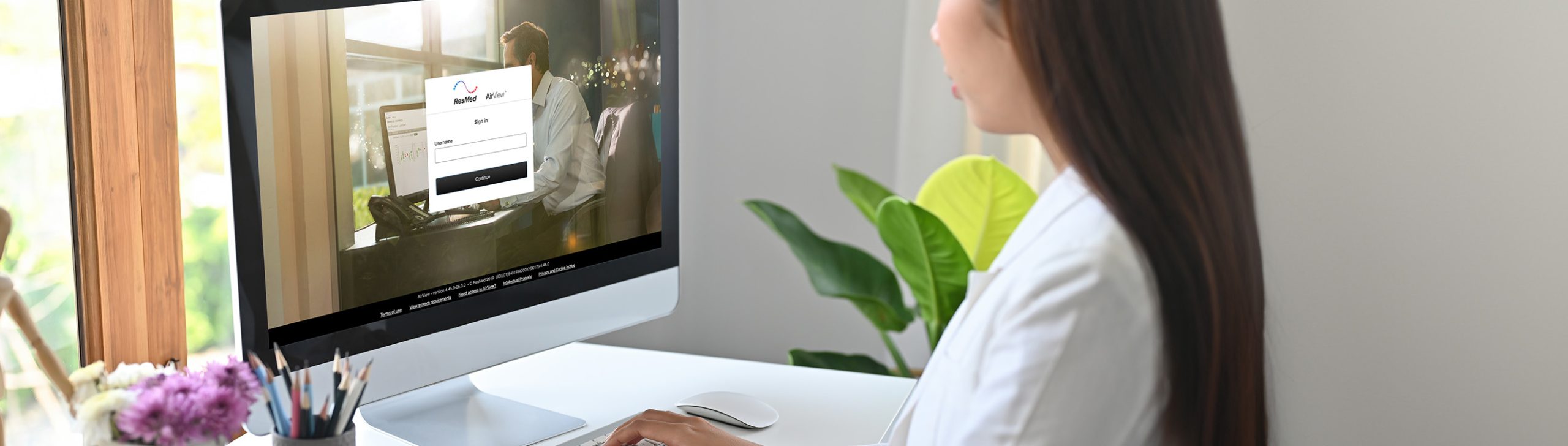 Frau sitzt vor einem Computer und nutzt das AirView™-Telemonitoring-Portal von ResMed.