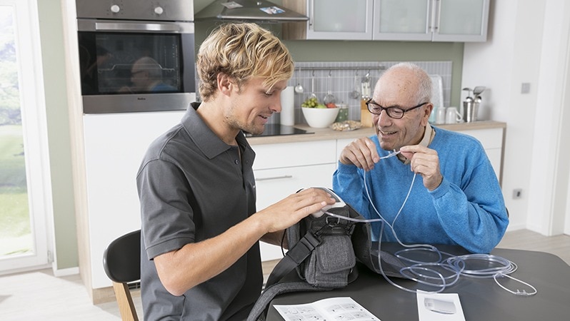 Senior erhält Beratung zur Sauerstofftherapie zu Hause.